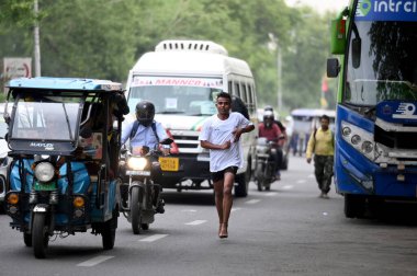 NOIDA INDIA APRIL 24 2023 Sansad Khel Spardha 2023 Maraton koşucuları 24 Nisan 2023 tarihinde Noida Hindistan 'da 21A sektöründe barikat kurmadan trafikte koşarken görüldü.