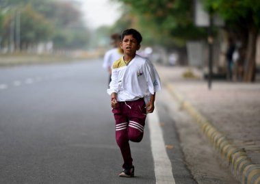 NOIDA INDIA APRIL 24 2023 Sansad Khel Spardha 2023 Maraton koşucuları 24 Nisan 2023 tarihinde Noida Hindistan 'da 21A sektöründe barikat kurmadan trafikte koşarken görüldü.