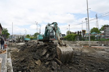 SRINAGAR INDIA APRIL 27 Nisan 2023 Bir makine Srinagar Hindistan 'da 27 Nisan 2023 tarihinde beton kaldırma şehir merkezi Lal Chowk yeni yollar döşemek için çalışma önümüzdeki ay planlanan G20 toplantısı öncesinde Srinagar şehri Srina altında yenileniyor