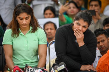 NEW DELHI, INDIA, APRIL 25, 2023 Hintli güreşçiler Bajrang Punia ve Vinesh Phogat ve Sakshi Malik, 25 Nisan 2023 tarihinde Jantar Mantar 'da Hindistan Güreş Federasyonu Başkanı' na karşı sürdürülen protesto sırasında basın toplantısı düzenlediler. 