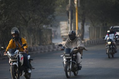 NEW DELHI, INDIA - 15 ARALIK 2024: İnsanlar kendilerini korumak için sıcak kıyafetler giydikleri görüldü soğuk bir sabah, Shaheen Bagh 'da, 15 Aralık 2024' te, Yeni Delhi, Hindistan 'da. 