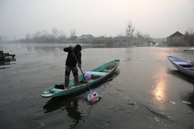 SRINAGAR INDIA 19 Aralık 2024 Bir kayıkçı, 19 Aralık 2024 'te Srinagar Hindistan' daki Dal Gölü 'nde kısmen donmuş sularda kürek çekerken Srinagar Vadisi' ni en soğuk hava dalgası kapladı.