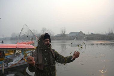 SRINAGAR INDIA DECEMBER 19 2024 A man shows ice sheets of partially frozen water of Dal Lake on Decemberr 19 2024 in Srinagar India An extreme cold wave gripped Kashmir Valley with Srinagar experiencing its coldest night of the season at minus 6 degr clipart