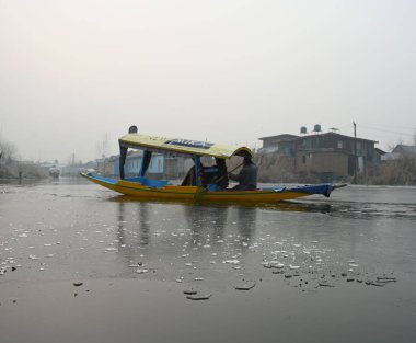 SRINAGAR INDIA 19 Aralık 2024 Bir kayıkçı, 19 Aralık 2024 'te Srinagar Hindistan' daki Dal Gölü 'nde kısmen donmuş sularda kürek çekerken Srinagar Vadisi' ni en soğuk hava dalgası kapladı.