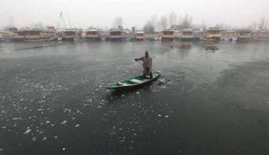 SRINAGAR INDIA 21 Aralık 2024 Bir kayıkçı 21 Aralık 2024 'te Srinagar Hindistan' da kısmen donmuş olan Dal Gölü 'nün yüzeyinden geçerek soğuk bir dalganın pençesine düştü ve Chillai Kalan' ın 40 günlük büyük soğuğu Vall 'da başladı.