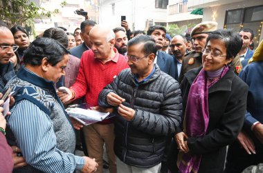 NEW DELHI INDIA DECEMBER 23 2024 Delhi CM Atishi AAP National convener Arvind Kejriwal Manish Sisodia during a door to door registration of Sanjeevani Yojana promising free health care for senior citizens at Jangpura Assembly Constituency on December clipart