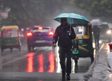 NOIDA, INDIA - 27 Aralık 2024 'te Hindistan' ın Noida kentinde kış yağmuru sırasında Kuzey Hindistan 'da şiddetli soğuk hava dalgalarına yağmur yağdı. Delhi ve yakındaki bölgelerde mod alındı