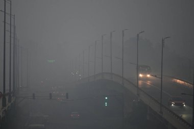 NEW DELHI, INDIA - 25 Aralık 2024: Dün yağmurdan sonra, Yeni Delhi, Hindistan 'da, 25 Aralık 2024 tarihinde, Ring Road Sarai Kale Khan' da sisli bir sabah manzarası. Soğuk hava dalgası Hindistan 'ı vurdu ve bazı eyaletler aşırı soğuk koşullarla boğuşuyor.. 