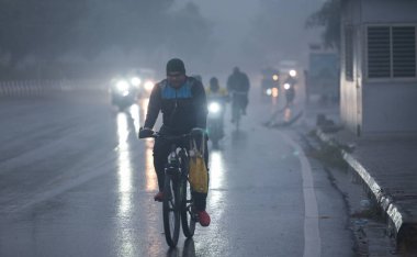 NEW DELHI, INDIA - 27 Aralık 2024: Yeni Delhi, Hindistan 'da 27 Aralık 2024' te, Connaught Place Circle 'da, soğuk ve yağmurlu bir günde banliyö dışındalar. Delhi ve yakındaki bölgelere Cuma günü orta şiddette yağmur yağdı.