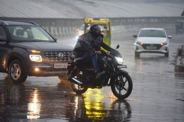 GURUGRAM, INDIA - 27 Aralık 2024: İnsanlar 27 Aralık 2024 'te Hindistan' ın Gurugram kentinde, bölge mahkemesi yakınlarındaki Rajiv Chowk 'ta kış sabahı yağmur yağarken işyerlerine gidiyorlar. Delhi ve yakındaki bölgelere Cuma günü orta şiddette yağmur yağdı. 