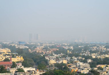 26 Aralık 2024 Noida Hindistan 'da 26 Aralık 2024 günü öğleden sonra yükselen hava kirliliği ve sisli hava nedeniyle gökdelenlerin görüntüsü sisli bir hava dalgası Hindistan' ı vurdu.