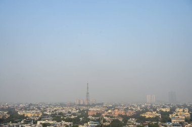 26 Aralık 2024 Noida Hindistan 'da 26 Aralık 2024 günü öğleden sonra yükselen hava kirliliği ve sisli hava nedeniyle gökdelenlerin görüntüsü sisli bir hava dalgası Hindistan' ı vurdu.