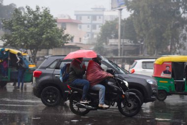 GURUGRAM INDIA 27 ARALIK 2024 Bir kış sabahı Rajiv Chowk 'ta 27 Aralık 2024 tarihinde Hindistan Gurugram' da ve yakınlarındaki bölgelerde yağmur damlalarına yol açan hafif ve şiddetli bir yağmurla Cuma günü işyerlerine giden insanlar 