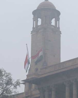 YENİ DELHI INDIA 27 ARALIK 2024 Kuzey bloğu ve güney bloğunda yarıya kadar dalgalanan ulusal bayrak, eski Başbakan Manmohan Singh 'e saygı göstergesi olarak ülkede bir haftalık devlet yasının gözlendiği 27 Aralık 2024 tarihinde New D' de görülüyor.