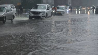 NEW DELHI INDIA 27 ARALIK 2024 Banliyö sakinleri, 27 Aralık 2024 tarihinde Ashram Chowk yakınlarındaki soğuk bir kış akşamında yağmurdan sonra yağmurlu bir su boyunca yürüdü.