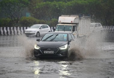 NOIDA INDIA 27 ARALIK 2024 GİRİŞ YAŞAĞI, 27 Aralık 2024 tarihinde Noida Hindistan 'da yağışlı olduğu için 95. Sektördeki sulu bir yoldan geçiyor.