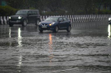 NOIDA INDIA 27 ARALIK 2024 GİRİŞ YAŞAĞI, 27 Aralık 2024 tarihinde Noida Hindistan 'da yağışlı olduğu için 95. Sektördeki sulu bir yoldan geçiyor.