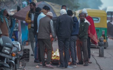 NEW DELHI INDIA DECEMBER 30 2024 People are gathered around bonfires to protect themselves on a cold winter morning at NH24 Near Narwana Road on December 30 2024 in New Delhi India North India is reeling under cold weather with temperatures plummetin clipart