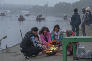 NEW DELHI INDIA DECEMBER 30 2024 People are gathered around bonfires to protect themselves on a cold winter morning at Yamuna Ghat on December 30 2024 in New Delhi India North India is reeling under cold weather with temperatures plummeting across se clipart