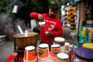 NOIDA INDIA 30 ARALIK 2024 Soğuk bir sabahta yol kenarında çay yapan bir çay satıcısı Delhi 'de soğuk algınlığı arttı NCR cıvası daha da düştü 30 Aralık 2024' te Noida Hindistan 'da sabah sıcaklığı 8C idi 