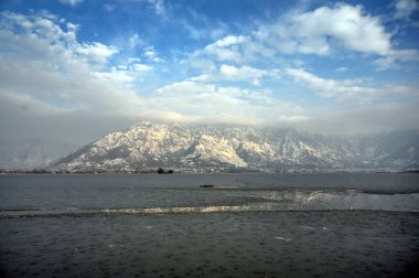 30 Aralık 2024 'te Hindistan' ın Srinagar kentinde kar dağları ve donmuş Dal Gölü 'nü gösteren genel bir bakış açısı vardır. Kaşmir 'e Cuma ve Cumartesi günü yoğun kar yağışı yağdı ve bu da vadinin bazı bölgelerinin kapatılmasına yol açtı. 