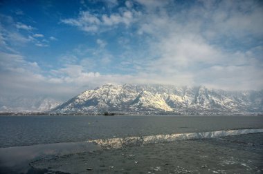 30 Aralık 2024 'te Hindistan' ın Srinagar kentinde kar dağları ve donmuş Dal Gölü 'nü gösteren genel bir bakış açısı vardır. Kaşmir 'e Cuma ve Cumartesi günü yoğun kar yağışı yağdı ve bu da vadinin bazı bölgelerinin kapatılmasına yol açtı. 