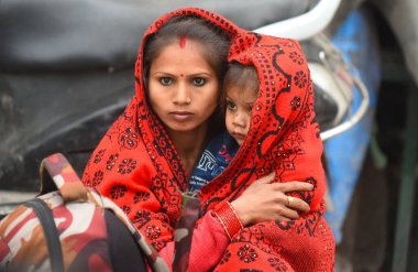 NEW DELHI INDIA 31 ARALIK 2024 Bir kadın soğuk bir kış sabahı çocuğunu Kapashera bölgesindeki bir polis karakoluna saran bir şala sarmak için otobüs bekliyor. 31 Aralık 2024 'te Delhi' nin güneybatısında Yeni Delhi 'de. Fotoğraf: Parveen Kumar Hindustan