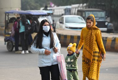 NOIDA, INDIA - 31 ARALIK: 38. bölgede banliyö görevlileri kalın giysiler içinde dışarı çıktılar. Delhi NCR 'de soğuk hava dalgası 31 Aralık 2024' te Hindistan 'ın Noida şehrinde hakim olmuştur. (Fotoğraf: Sunil Ghosh / Hindustan Times 