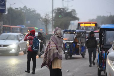 NEW DELHI, INDIA - 31 Aralık 2024 tarihinde Hindistan 'ın Yeni Delhi kentinde, Delhi-Gurugram sınırı yakınlarındaki Güney Batı Delhi' nin Kapashera bölgesinde, soğuk bir kış sabahı insanlar işe giderken sıcak kıyafetler giyiyorlar. Fotoğraf: Parveen Kumar / Hindustan