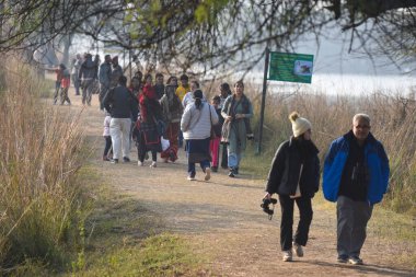 Kuş severler, 5 Ocak 2025 'te Hindistan' ın Gurugram kentindeki Sultanpur köyü yakınlarındaki Farrukhnagar yolu üzerindeki Ulusal Kuş Günü münasebetiyle kuşu izlemek üzere Sultanpur Milli Parkı 'na gelirler.. 