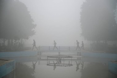 GURUGRAM INDIA JANUARY 5 2025 People seen exercising amid cold and foggy weather in Leisure Valley Park at sector 29 near Huda Market on January 5 2025 in Gurugram India A dense blanket of fog once again engulfed national capital Delhi on Saturday mo clipart