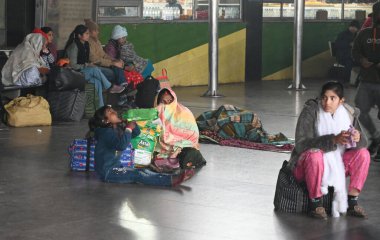 NEW DELHI INDIA 4 JANUARY 4. 2025 Yolcular, Yeni Delhi Tren İstasyonu 'nda kendilerini yünlü kumaşlarla örten bir platformda oturuyorlar 4 Ocak 2025' te yoğun sis nedeniyle yoğun tren seferleri bir zamanlar agai yoğun bir sis örtüsü altında kalmıştır.