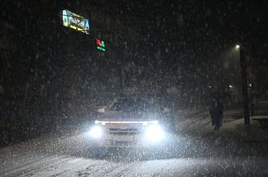 5 Ocak 2025 'te Srinagar Hindistan' da kar yağışı sırasında SRINAGAR INDIA HAZİRAN 5 2025 Araçlar yolda ilerlerken, Srinagar şehri de dahil olmak üzere Kaşmir 'in çoğu bölgesi Pazar günü Merkür' ün dondurucu soğuğa yakın durmasıyla taze bir kar yağışı aldı.