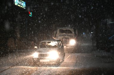 5 Ocak 2025 'te Srinagar Hindistan' da kar yağışı sırasında SRINAGAR INDIA HAZİRAN 5 2025 Araçlar yolda ilerlerken, Srinagar şehri de dahil olmak üzere Kaşmir 'in çoğu bölgesi Pazar günü Merkür' ün dondurucu soğuğa yakın durmasıyla taze bir kar yağışı aldı.