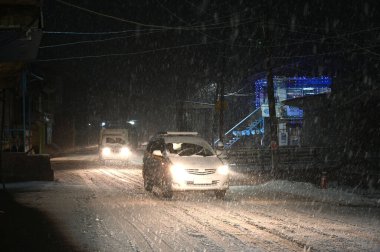 5 Ocak 2025 'te Srinagar Hindistan' da kar yağışı sırasında SRINAGAR INDIA HAZİRAN 5 2025 Araçlar yolda ilerlerken, Srinagar şehri de dahil olmak üzere Kaşmir 'in çoğu bölgesi Pazar günü Merkür' ün dondurucu soğuğa yakın durmasıyla taze bir kar yağışı aldı.