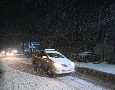 5 Ocak 2025 'te Srinagar Hindistan' da kar yağışı sırasında SRINAGAR INDIA HAZİRAN 5 2025 Araçlar yolda ilerlerken, Srinagar şehri de dahil olmak üzere Kaşmir 'in çoğu bölgesi Pazar günü Merkür' ün dondurucu soğuğa yakın durmasıyla taze bir kar yağışı aldı.