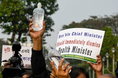 KOLKATA INDIA JANUARY 13 2025 Congress activists hold a saline water bottle during protest rally from Karunamoyee to Swasthya Bhavan against death of a woman after administered expired saline water produced by Paschim Banga Pharmaceuticals Ltd and de clipart