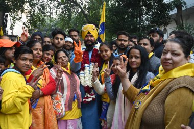 NEW DELHI INDIA JANUARY 14 2025 AAP candidate from Shahdara assembly Jitender Singh Shanty dresses up with PPE Kit with Coverall Gown Hand Gloves Shoe Cover and Head Cover Safety with suppoters road show at Jhilmil Colony before filling nomination  clipart