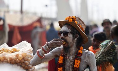PRAYAGRAJ INDIA 2 Şubat 2025 Bir naga Sadhu 2 Şubat 2025 tarihinde Mahakumbh Mela sırasında sokak yemeklerinin keyfini çıkarıyor Prayagraj Hindistan Fotoğraf: Deepak Gupta Hindustan Saati