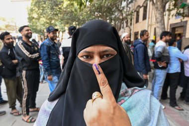 NEW DELHI INDIA FEBRUARY 5. 2025 Müslüman bir kadın, 5 Şubat 2025 tarihinde Yeni Delhi 'de Jafrabad seçim merkezinde oyunu kullandıktan sonra mürekkep lekeli parmağıyla poz verdi. 