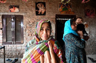 NEW DELHI, INDIA - FEBRUARY 5, 2025: Pakistan Hindu Refugees Now Indian Citizen showing inked finger after casting their first vote at Majnu Ka Tila Refugees camp on February 5 2025 in New Delhi India. clipart