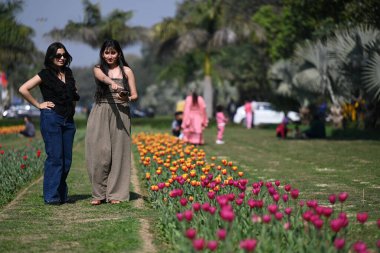 Delhililer, Shanti Yolu, Chanakyapuri 'de Full Bloom laleleri eşliğinde 9 Şubat 2025' te Yeni Delhi, Hindistan 'da güneşli bir öğleden sonranın tadını çıkarıyorlar.. 