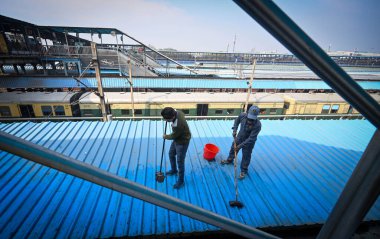 NEW DELHI, INDIA - 16 Şubat 2025 'te Yeni Delhi, Hindistan' da 18 kişinin dün Yeni Delhi Tren İstasyonu 'ndaki izdiham sonucu hayatını kaybettiği bildirilen demiryolu platformlarını temizlerken görülen bir işçi.