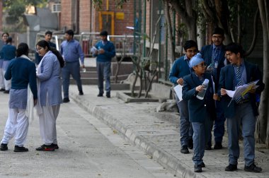 NEW DELHI, INDIA - FEBRUARY 15,2025: Students coming out from the exam centre after appearing the CBSE class 10th exam, at Bhartiya Vidya bhawan, KG Marg, on February 15, 2025 in New Delhi, India.  clipart