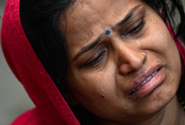 NEW DELHI, INDIA - FEBRUARY 16, 2025: Family members of Pinki Devi (who died) in grief at residence near Sangam Vihar, after New Delhi Railway station stampede last night, on February 16, 2025 in New Delhi, India.  clipart