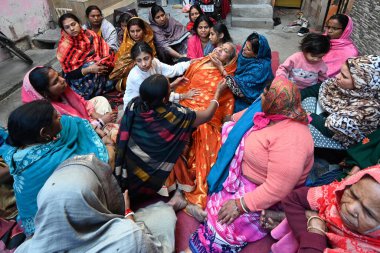 NEW DELHI, INDIA - FEBRUARY 16, 2025: Family members of Pinki Devi (who died) in grief at residence near Sangam Vihar, after New Delhi Railway station stampede last night, on February 16, 2025 in New Delhi, India.  clipart