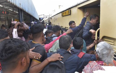 GHAZIABAD, INDIA - 17 Şubat 2025 'te Ghaziabad, Hindistan' da Ghaziabad Junction tren istasyonundaki kalabalık birbirlerini trene binmeye ve hareket halindeki trene tutunmaya zorluyor.. 