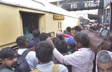 GHAZIABAD, INDIA - 17 Şubat 2025 'te Ghaziabad, Hindistan' da Ghaziabad Junction tren istasyonundaki kalabalık birbirlerini trene binmeye ve hareket halindeki trene tutunmaya zorluyor.. 