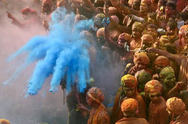 İnsanlar 9 Mart 2025 'te Hindistan' ın Mathura kentinde Nandji Tapınağı 'ndaki Lathmar Holi festivali sırasında birbirlerine renkli pudra sürerler.. 