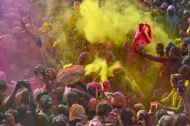İnsanlar 9 Mart 2025 'te Hindistan' ın Mathura kentinde Nandji Tapınağı 'ndaki Lathmar Holi festivali sırasında birbirlerine renkli pudra sürerler.. 